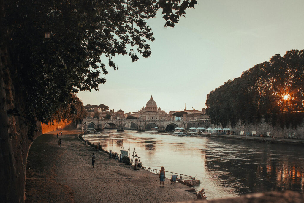 Scopri le meraviglie di Roma. Vista di Roma al tramonto con il Tevere e la cupola di San Pietro sullo sfondo